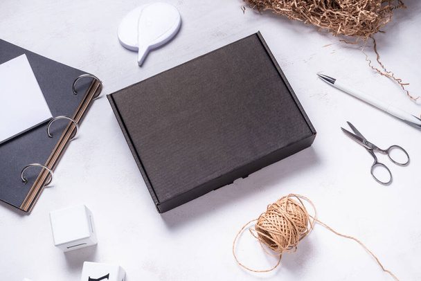 Black cardboard box on wooden office desk - Fotó, kép