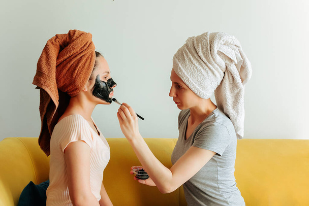 applying the cosmetic mask on the womans face. - Φωτογραφία, εικόνα