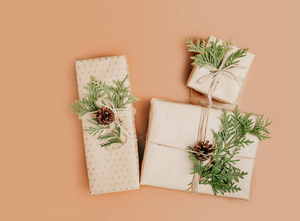 Gift boxes wrapped in craft paper and decorated with green cypress branch - Photo, image