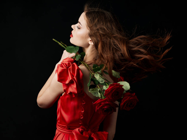 γυναίκα σε κόκκινο φόρεμα λουλούδια δώρο πολυτέλεια ειδύλλιο - Φωτογραφία, εικόνα