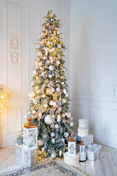 beautiful large elegant Christmas tree with gifts and lanterns in the white room - Valokuva, kuva
