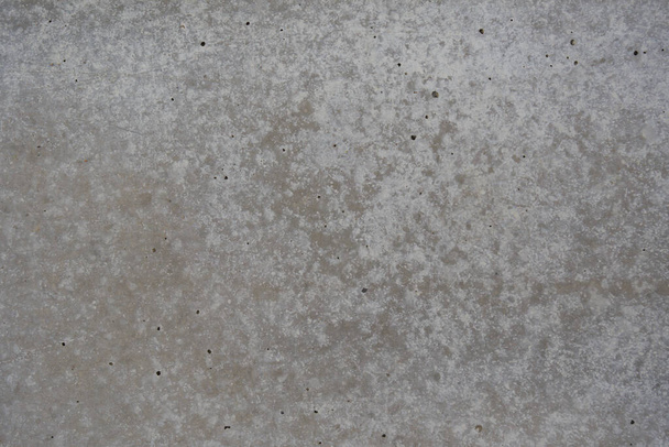 betonnen textuur van dichtbij. Er zijn kleine scheuren op het betonnen oppervlak, die een interessante textuur structuur creëren. overgang van tinten. kan worden gebruikt als een foto achtergrond - Foto, afbeelding