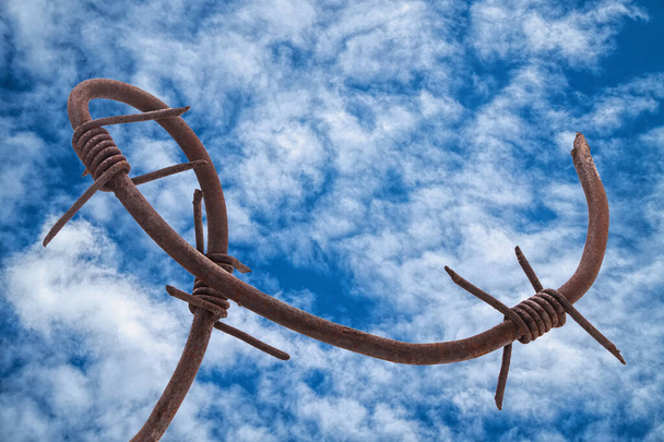 Viejo alambre de púas oxidado roto contra el cielo dramático. Concepto de libertad - Foto, Imagen