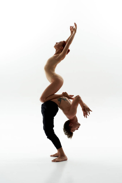 vrouw zitten op buik van partner tijdens ballet dans - Foto, afbeelding