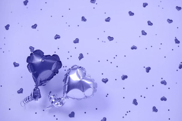 Due palloncini d'aria di lamina di metallo a forma di cuore su colore viola festivo. - Foto, immagini