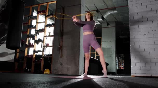 Mujer joven jugando con una cuerda de salto en el gimnasio - Metraje, vídeo