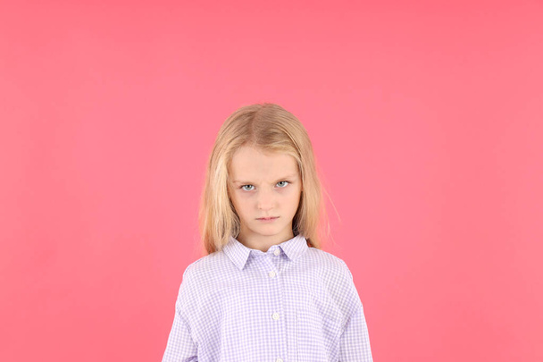 Θυμωμένο κοριτσάκι με πουκάμισο σε ροζ φόντο - Φωτογραφία, εικόνα