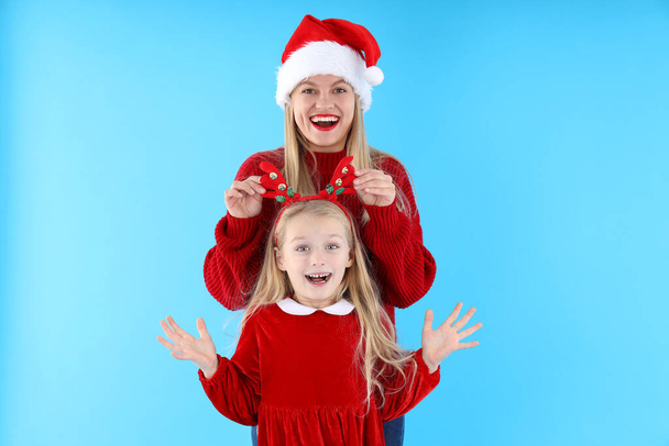 Mom and daughter on blue background, Christmas concept - 写真・画像