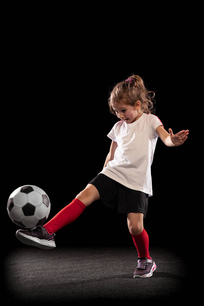 Retrato completo de menina brincalhão, criança em movimento, ação, treinamento isolado sobre fundo preto - Foto, Imagem