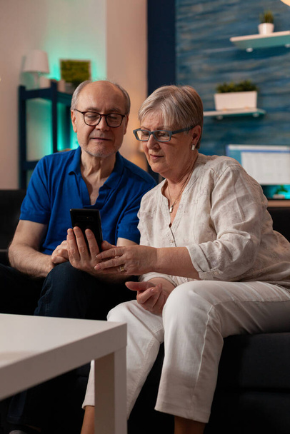 Відставний чоловік і дружина дивиться на екран смартфона
 - Фото, зображення