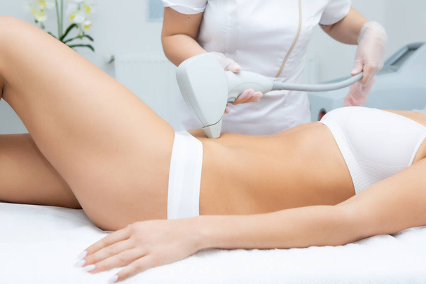 the girl is given laser hair removal. Laser hair removal concept - Valokuva, kuva