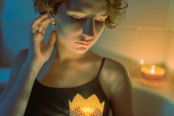 Muotokuva mietteliäs nuori nainen teini ruskea kihara tukka bikinit olkahihnat kynttilät käsissään suoristus hänen hiukset - Valokuva, kuva