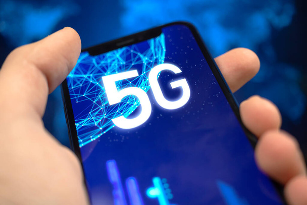 Adam 5G ağ bağlantısı olan akıllı telefon kullanıyor. Yüksek hızlı mobil internetin geleceği, küresel kablosuz teknoloji geçmişi - Fotoğraf, Görsel