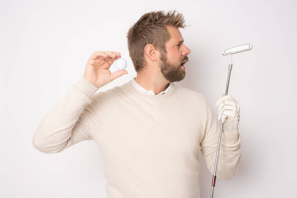 Young handsome man playing golf standing isolated over white background. - Foto, Bild