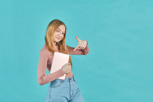 Счастливая девушка с помощью планшетного компьютера. Улыбающаяся молодая женщина с планшетным ПК, изолированная на синем фоне. Молодежь и технологии. Снимок студии. - Фото, изображение