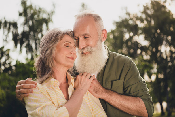 Photo of nice elder white hair couple hug wear casual shirts outdoors day off in park - Photo, Image