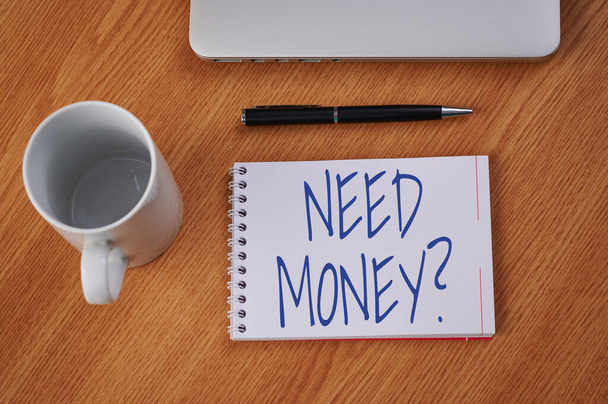 Konzeptpräsentation braucht Geldfrage. Geschäftsidee, jemanden zu fragen, ob er Bargeld oder Geschenke braucht Geschlossener Laptop neben leerem Tagebuch mit Stift und Kaffeebecher über dem Tisch. - Foto, Bild