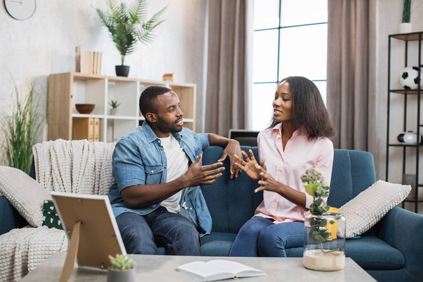 African american couple sitting on couch and chatting - Photo, image