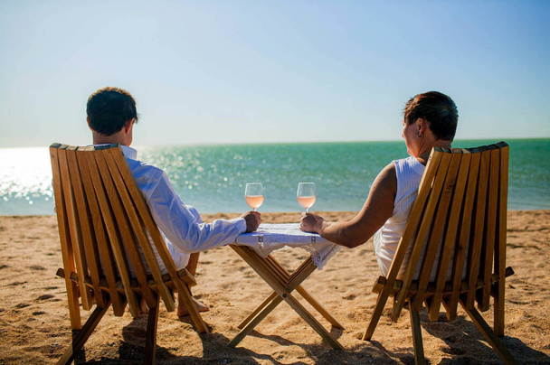 âge, tourisme, voyage et concept de personnes. heureux couple de personnes âgées buvant du champagne ou du vin sur la plage près de la mer. - Photo, image