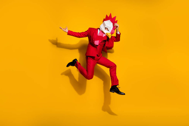 Photo of carefree model guy absurd jump wear cock polygonal mask red tux shoes isolated yellow color background - Fotografie, Obrázek