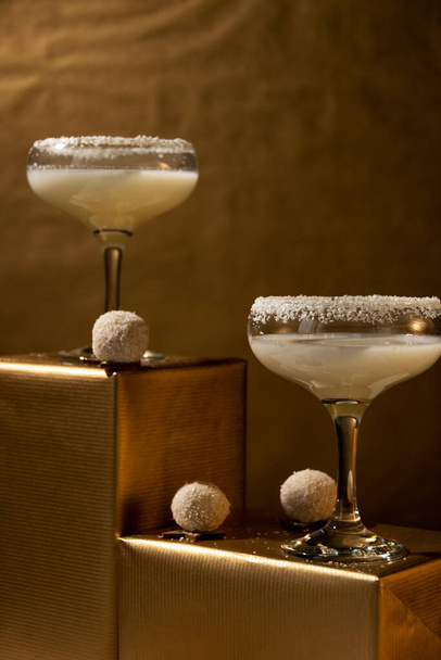 Slavnostní nápoje. Bílé koktejly sklenice na zlatém pozadí. Koncept oslavy - Fotografie, Obrázek