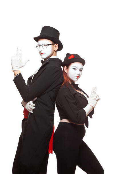 Portrait of two mime artists performing, isolated on white background. Pretending to hold guns. Symbol of team, partners, Bonnie and Clyde - Foto, afbeelding