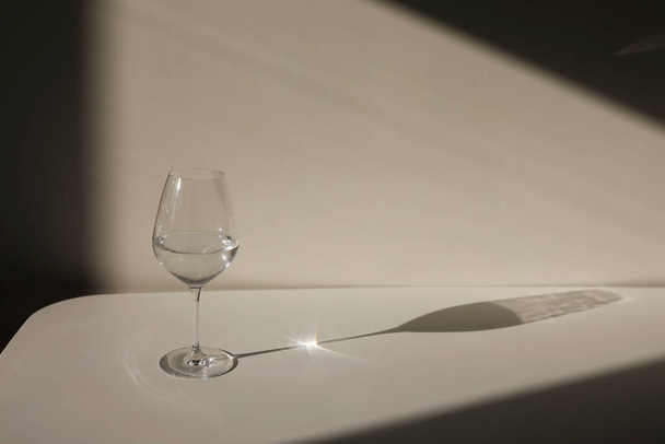 a glass of white wine or champagne. Chiaroscuro from the window. Close-up, copy space - Fotoğraf, Görsel