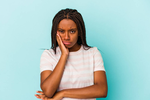 Mavi arka planda izole edilmiş, sıkılmış, yorgun ve dinlenmeye ihtiyacı olan genç Afrikalı Amerikalı kadın.. - Fotoğraf, Görsel