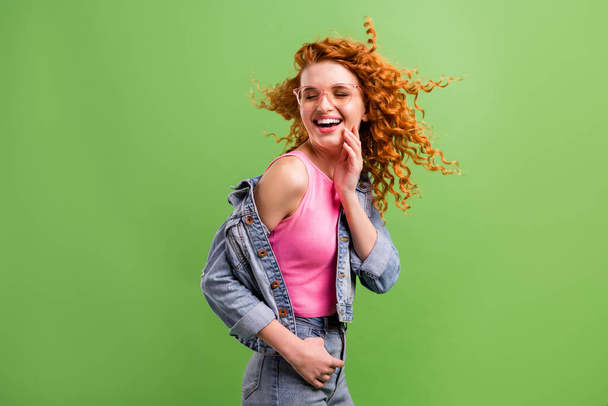Foto de bonito adorável jovem mulher desgaste jeans roupa óculos braço bochecha sorrindo isolado cor verde fundo - Foto, Imagem