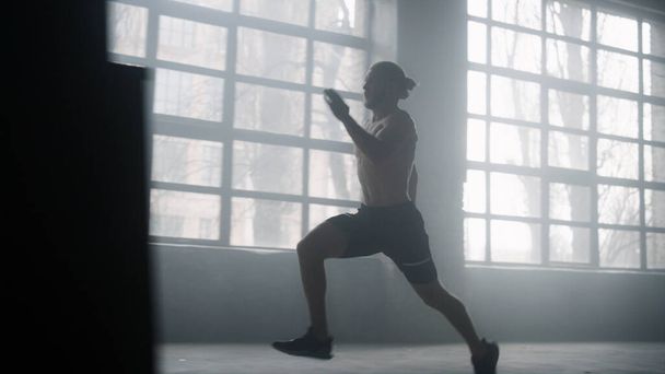 Athlete standing on start position in crossfit gym. Man running in loft building - Фото, зображення