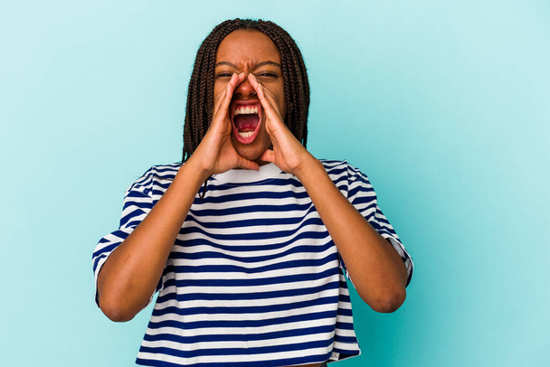 Young african american woman isolated on blue background  shouting excited to front. - Photo, Image