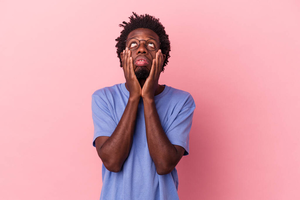 jonge afrikaanse amerikaanse man geïsoleerd op roze achtergrond jammeren en huilen troosteloos. - Foto, afbeelding