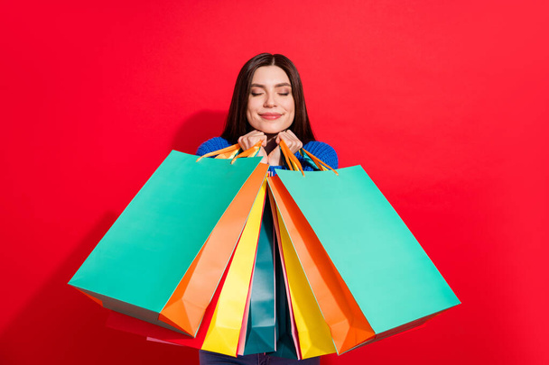 Photo of cheerful happy cute nice young woman enjoy shopping hold bags isolated on red color background - Fotografie, Obrázek