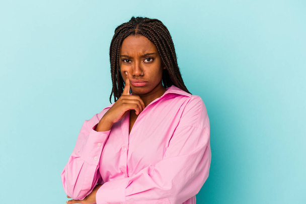 Young african american woman isolated on blue background  unhappy looking in camera with sarcastic expression. - Фото, изображение