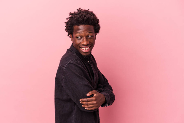 Молодий афроамериканець ізольований на рожевому фоні сміючись і отримуючи задоволення.. - Фото, зображення