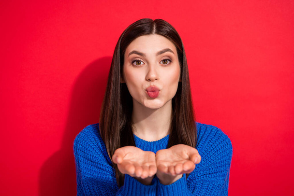 Photo portrait brunette sending air kiss to you on date dreamy in blue sweater isolated on vibrant red color background - Fotó, kép