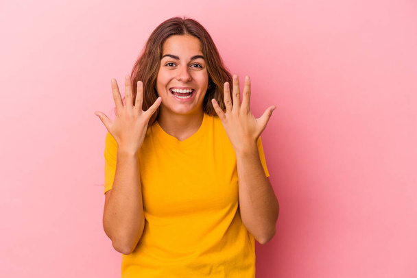 Young caucasian woman isolated on pink background  showing number ten with hands. - Foto, Bild