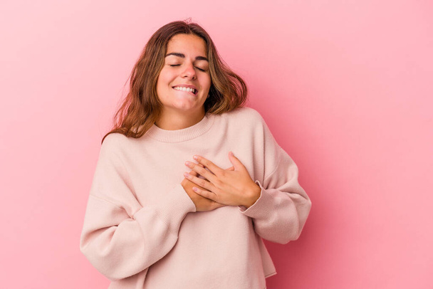 Young caucasian woman isolated on pink background  has friendly expression, pressing palm to chest. Love concept. - Foto, Imagem