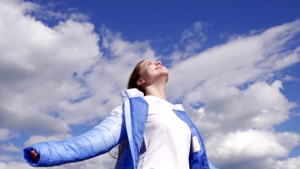 χαρούμενο παιδί με φθινοπωρινό μπουφάν απολαύστε τον ήλιο στο φόντο του ουρανού, ελευθερία - Πλάνα, βίντεο