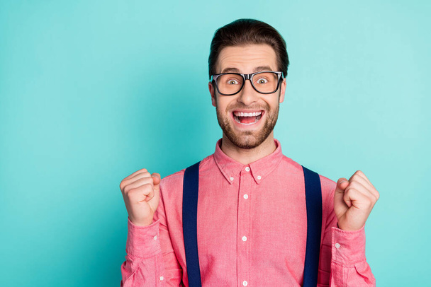 Photo of young excited man happy positive smile rejoice victory success fists hands isolated over teal color background - 写真・画像