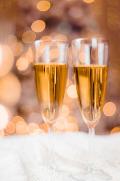 Champagne glazen op de achtergrond van een kerstboom. Feestelijke drankjes. Alcoholhoudende dranken. - Foto, afbeelding