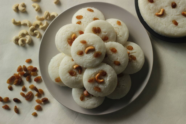 Vattappam in Idly shape. Steamed rice cake made of sweet fermented batter of rice and coconut, topped with raisins steamed using Idly mould. A new version of traditional snack from south kerala - Photo, Image