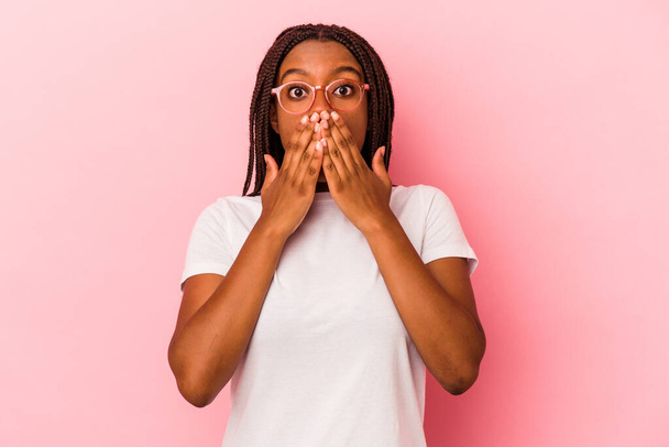 Junge Afroamerikanerin isoliert auf rosa Hintergrund schockiert Mund mit Händen bedecken. - Foto, Bild