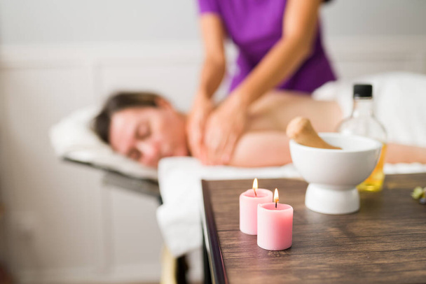Aromaterapie. Detailní záběr svíček, oleje a ingrediencí pro masáž obličeje a v kosmetických lázních  - Fotografie, Obrázek