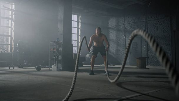 Člověk cvičí s bojovými lany. Sportovec dělá funkční trénink - Fotografie, Obrázek