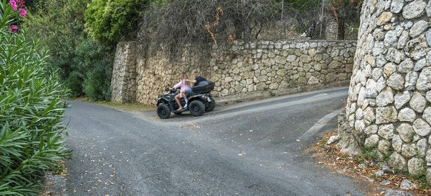 Yunanistan 'daki bir dağdan dört tekerli bisiklete binen iki kişi. - Fotoğraf, Görsel