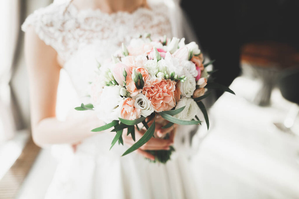 Bride holding big and beautiful wedding bouquet with flowers. - Fotó, kép