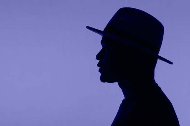 Mann Silhouette Pose mit Hut auf sehr peri Farbe 2022 Hintergrund mit Kopierraum - Foto, Bild