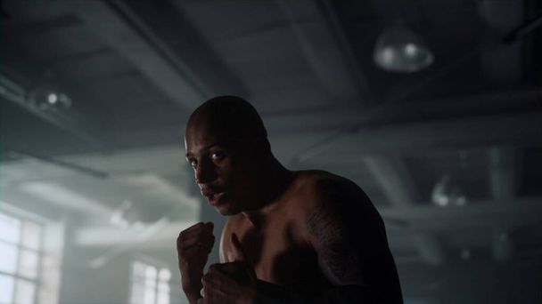 Man training box in sport club. Professional boxer fighting with shadow - Valokuva, kuva