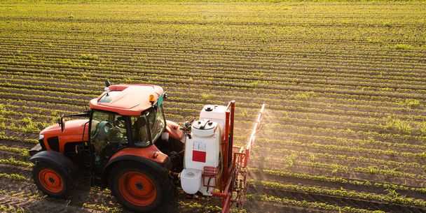 Traktor permetező peszticidek szójaföldön permetezővel tavasszal - Fotó, kép